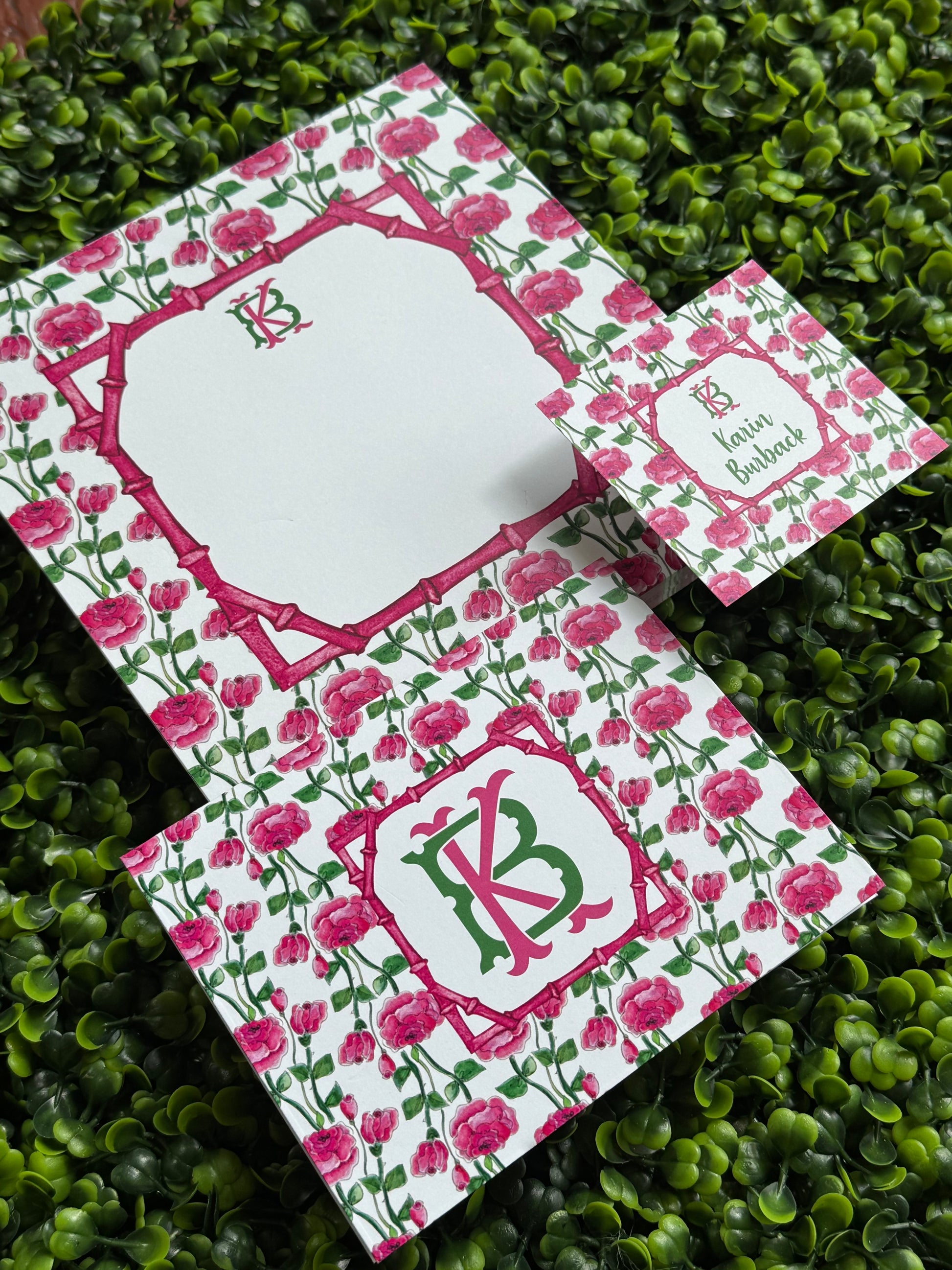 Floral stationery set with pink flowers and a green border on a grassy background